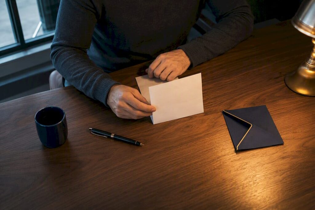 Hands drafting an apology at a quiet table