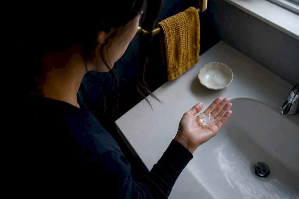 Woman using ice cube for grounding